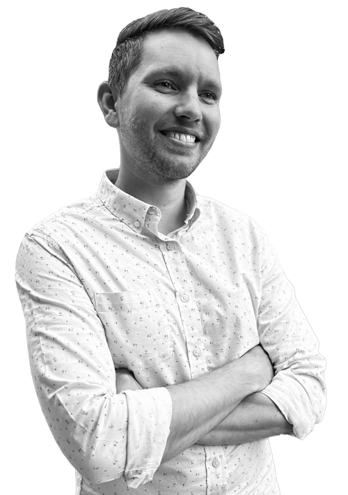 Garrett Danielson smiling, seated in a black-and-white portrait