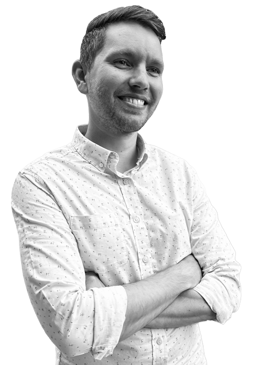 Garrett Danielson smiling with arms crossed in a black-and-white portrait