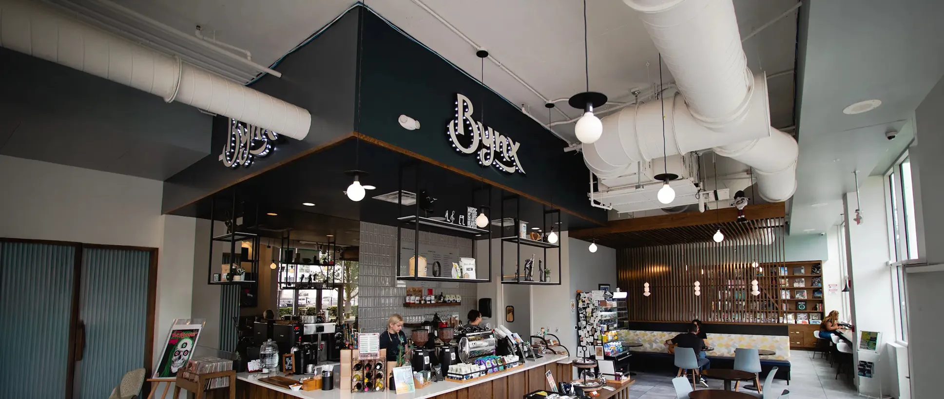 Hand-lettered Bynx logo over a photo of the coffee shop interior