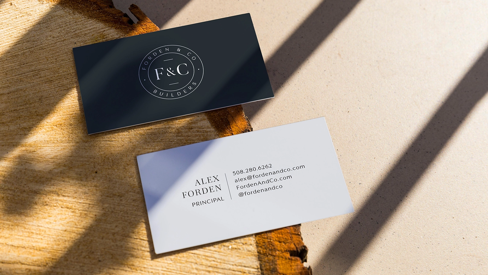 Forden & Co business cards with the seal logo on navy and contact details on white